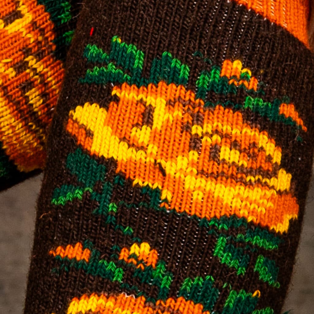 Cálidos calcetines de lana hasta la rodilla, en marrón oscuro, naranja y verde oscuro.