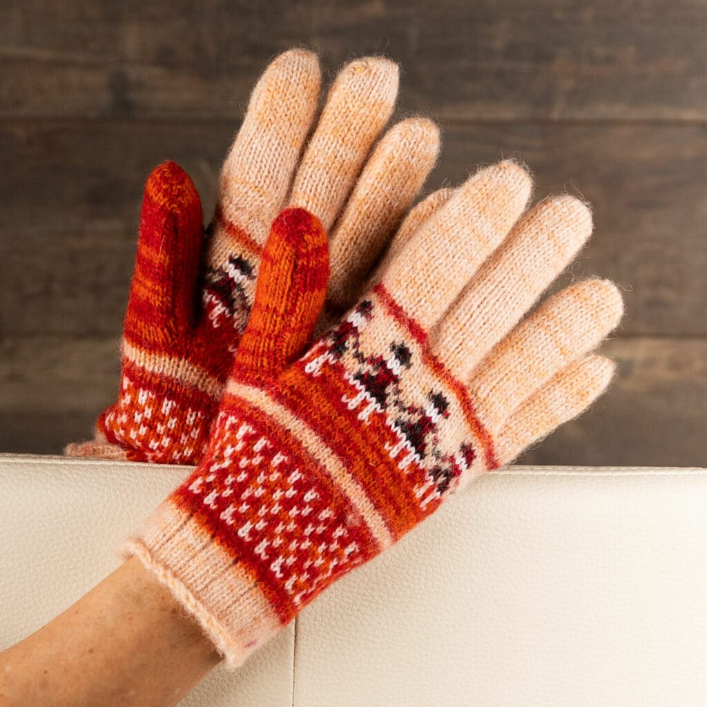 Preciosos guantes de cálida lana en rosa salmón y naranja, con bonito motivo de muñeca. Guantes cálidos para los amantes de los colores. Estos guantes están tejidos con pura lana de oveja. Si de verdad quieres mimar tus manos, estos guantes calentitos te vendrán como anillo al dedo. Sientes la artesanía y la calidad cuando los tienes en tus manos. Estos guantes son pura naturaleza. La lana de oveja es transpirable y aislante por naturaleza. ¡Gran regalo para cumpleaños o vacaciones!